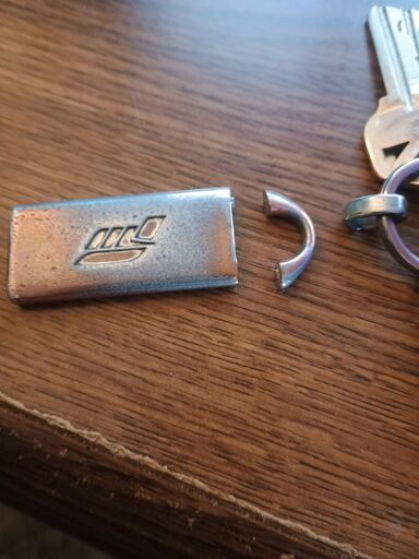 picture of a broken keyring with the logo for Forza Motorsport 3 on it